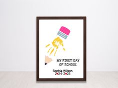 a framed poster with the words my first day of school and handprints on it