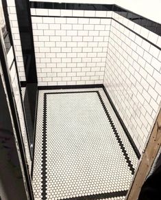 a bathroom with black and white tiles on the floor, walls and floors in it