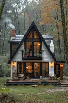 a small house in the woods with lots of windows and lights on it's roof