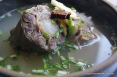 a bowl filled with meat and vegetables on top of a table