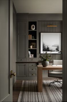 an office with gray walls and wooden floors, along with a white rug on the floor