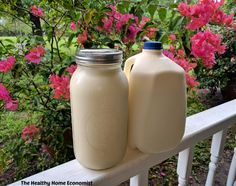 two jugs of milk are sitting on a porch rail