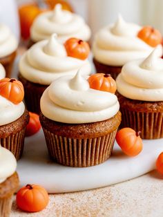 cupcakes with white frosting and pumpkin decorations