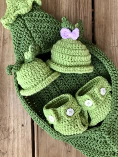 a crocheted hat, booties and diaper cover on a wooden surface