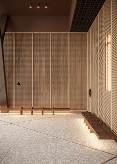 an empty room with wooden slats on the wall and steps leading up to it