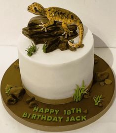 a birthday cake with a gecko on top