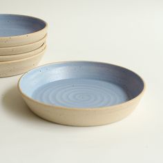 three blue and white bowls sitting on top of each other in front of a white background