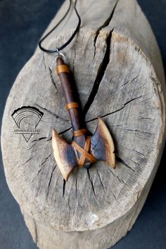 a wooden object that is on top of a piece of wood with a leather cord