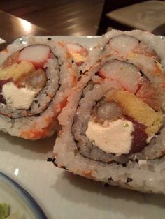 two sushi rolls on a white plate