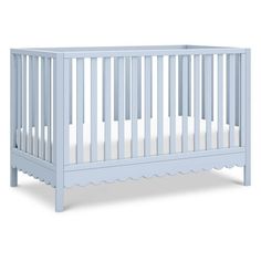 a baby crib with white sheets on the bottom and sides, in front of a white background