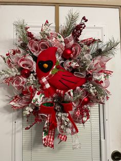 a red bird wreath hanging on the front door