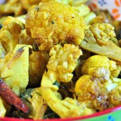 a colorful bowl filled with yellow and red cauliflower