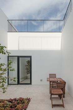 an empty patio with wooden chairs and table