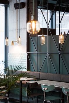 the interior of a restaurant with tables, chairs and lights hanging from the ceiling above them