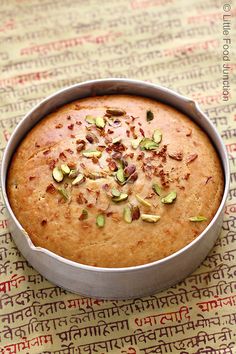 a cake in a pan with pistachios and nuts on top, ready to be eaten