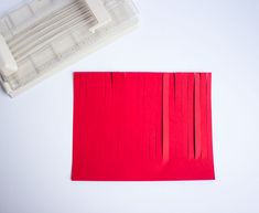 a red piece of paper next to a plastic ruler