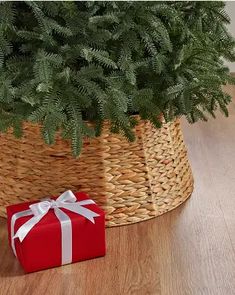 a christmas tree in a basket next to a red present