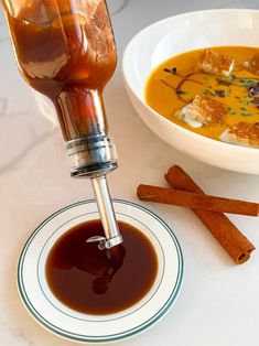 a bowl of soup and some cinnamon sticks