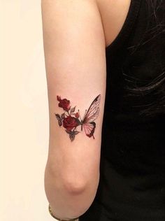 a woman with a tattoo on her arm has a rose and butterfly tattooed on it