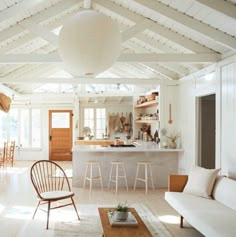 a living room filled with furniture next to a kitchen