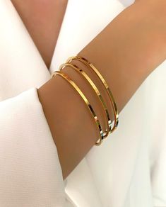 "The Gold Simple Plain Triple Bracelets 3x Set is perfect for everyday wear.  Crafted from stainless steel with a non-tarnish gold finish, these bracelets have two sizes options: 19cm(7.5\") and 20cm(7.9\") circumference.  They feature plain design and are easy to combine with any outfit.  Ideal for women who want to stay on trend, these triple bracelets will add a touch of glamour to your look. You can use them anytime in your daily life as they're resistant to tarnishing even when exposed to s Cheap Classic Round Bangle, Simple Gold Bangle, Gold Bangle Bracelets, Plain Gold Bangles, Gold Bracelet Simple, Gold Bangles For Women, Gold Bangle Set, Simple Bangle, Gold Bracelet Set