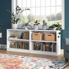 a living room with bookshelves and plants on the top shelf in front of a window