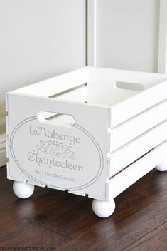 a white wooden crate sitting on top of a hard wood floor