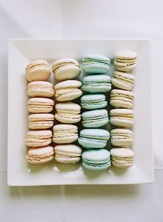 a white plate topped with lots of different colored macaroons