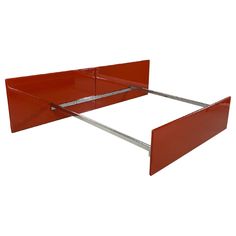 a red metal bed frame with two legs