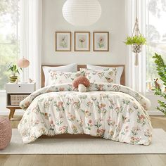 a bedroom with white walls and wooden flooring is decorated in pastel colors, including pinks and greens