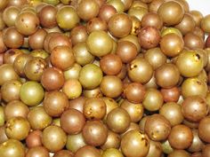 a pile of green and brown fruit sitting next to each other on top of a white surface