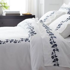 a white bed with blue flowers on it