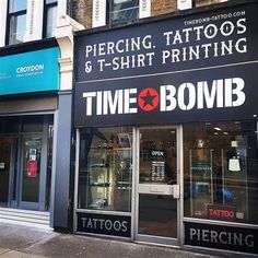 there is a tattoo and t - shirt printing shop on the corner of this street