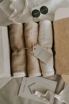 folded linens and tags are laid out on the bed for packaging to be wrapped in