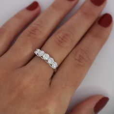 a woman's hand with a three stone ring on it