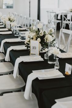 the tables are set up with black and white linens for an elegant wedding reception