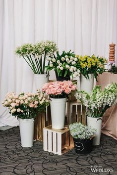 a bunch of flowers that are sitting in vases on a table next to each other