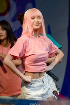 a woman with pink hair standing on stage