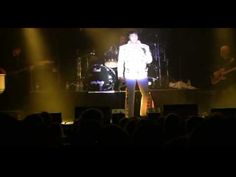 a man standing on top of a stage in front of a crowd