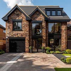 a large brick house with two garages on the front and one car door open