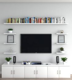 a flat screen tv mounted to the side of a wall next to bookshelves