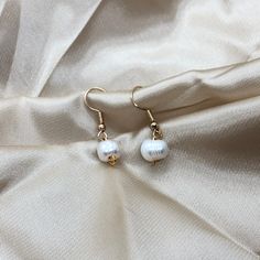 This is an elegant, minimalist , Pearl earring. These earrings are a great gift for anyone or a piece to level up your collection! -DETAILS- - Ivory Freshwater Pearl  - Gold colour hardware - Water resistant  -CARE-  - To avoid extreme tarnishing reduce contact with lotions, oils, and fragrances  - No abrasive materials should come in contact with the piece  - To clean simply fill a bowl with some soapy water do a cloth into the water and wipe  - If you need any repairs feel free to message us -SHIPPING- - We ship all of our orders with regular letter mail  - All of our orders are packaged with love and care -QUESTIONS- - If you have any questions or concerns feel free to message us  - If you want an order specially packaged you can message with requirements  - You can always personalize y Handmade Minimalist Pearl Drop Earrings, Handmade Minimalist Drop Pearl Earrings, Everyday Pearl White Drop Earrings, Pearl White Drop Earrings For Everyday Wear, Everyday Drop Earrings With Pearl Charm, Elegant White Everyday Earrings, Minimalist White Hoop Earrings With Pearl Charm, Pearl White Dangle Earrings For Everyday, Pearl White Round Earrings For Everyday