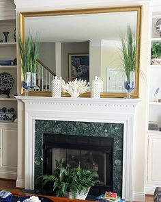 a living room filled with furniture and a fire place under a large mirror over a fireplace