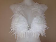 a mannequin with white feathers on it's back and some diamonds in the center