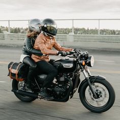 two people riding on the back of a motorcycle