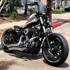 a black and silver motorcycle parked on the side of the road in front of a building