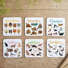 four coasters with different types of animals on them, sitting on a wooden table