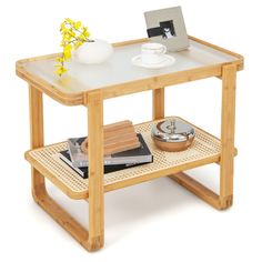 a wooden table with a white vase and yellow flowers on it, sitting next to other items