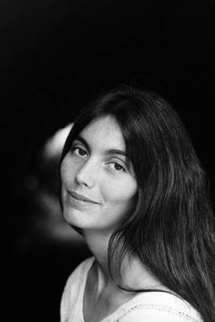 a black and white photo of a woman with long hair looking off to the side