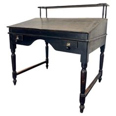 an old black desk with two drawers on the top and one drawer at the bottom